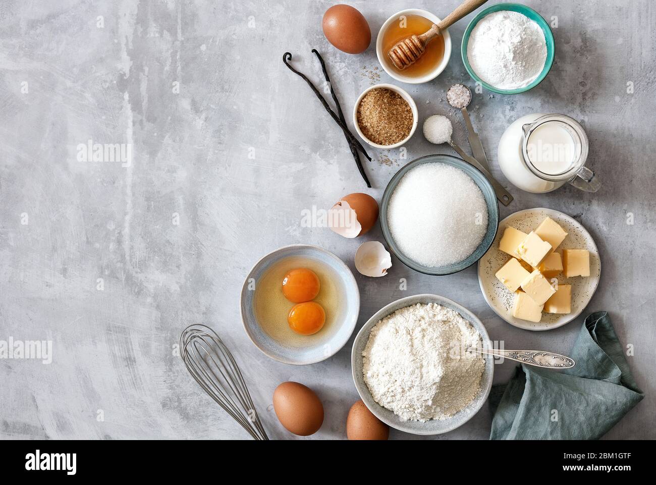 Ingredienti per la cottura: Farina, uova, zucchero, burro, latte e spezie  su sfondo grigio marmo. Vista dall'alto. Spazio per il testo Foto stock -  Alamy