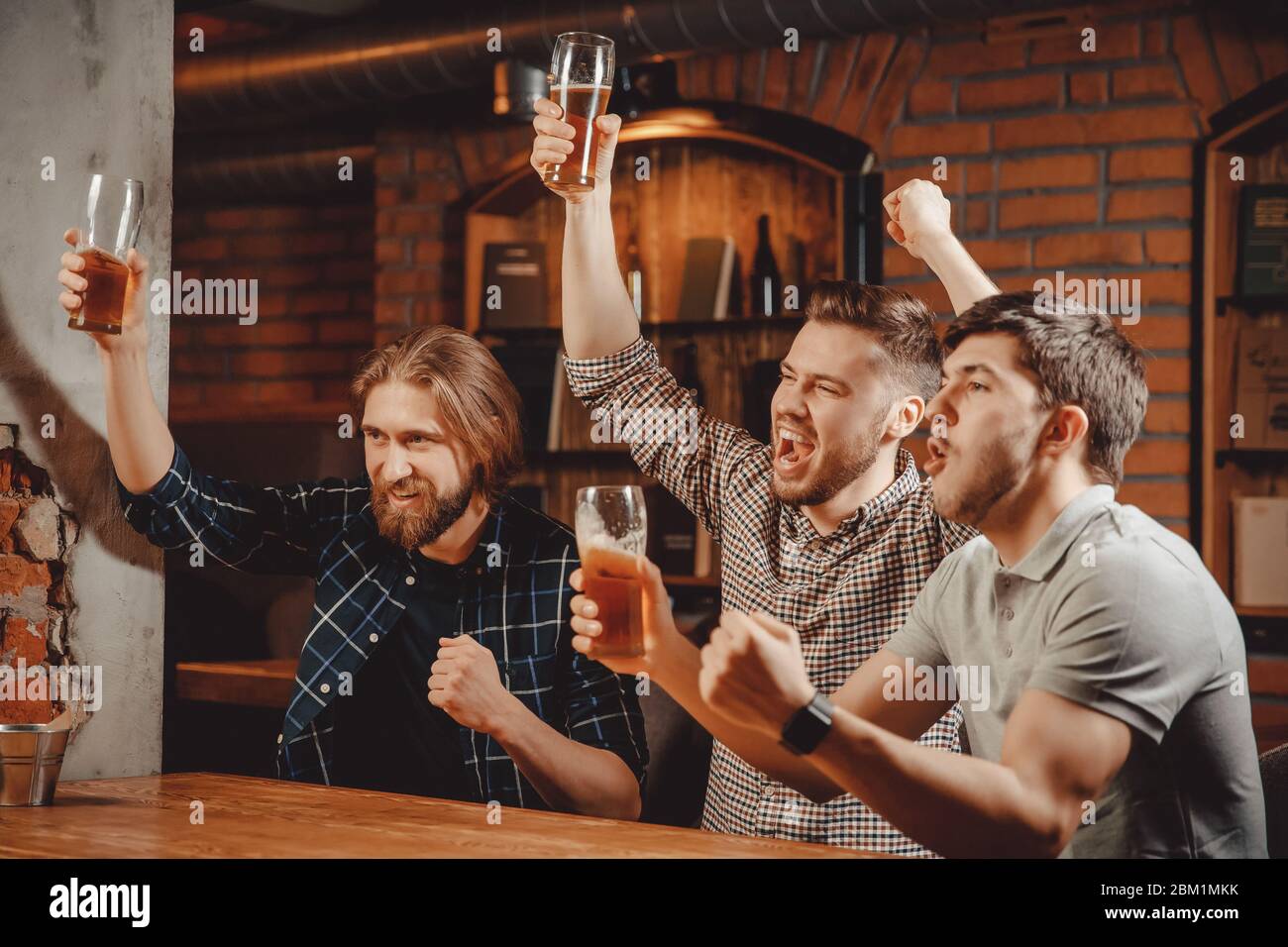 Gli appassionati di sport divertenti amici uomini sedersi nel bar bere  birra e guardare la partita di calcio in TV nel pub Foto stock - Alamy