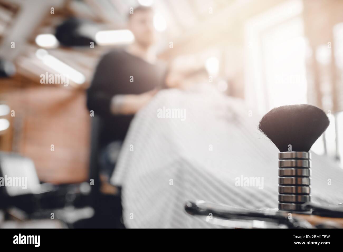 Barbiere, spazzola per barba e ciotola, sfondo sfocato del parrucchiere per uomo. Foto Stock