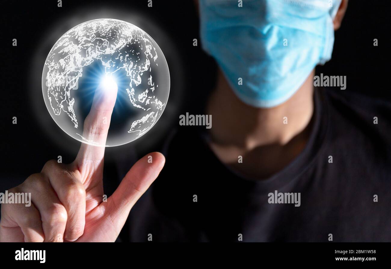 uomo d'affari che indossa la maschera durante il covid-19 e lavora da casa durante il covid, covid-19, touch 3d terra grafica con effetto luce al dito al tatto e co Foto Stock