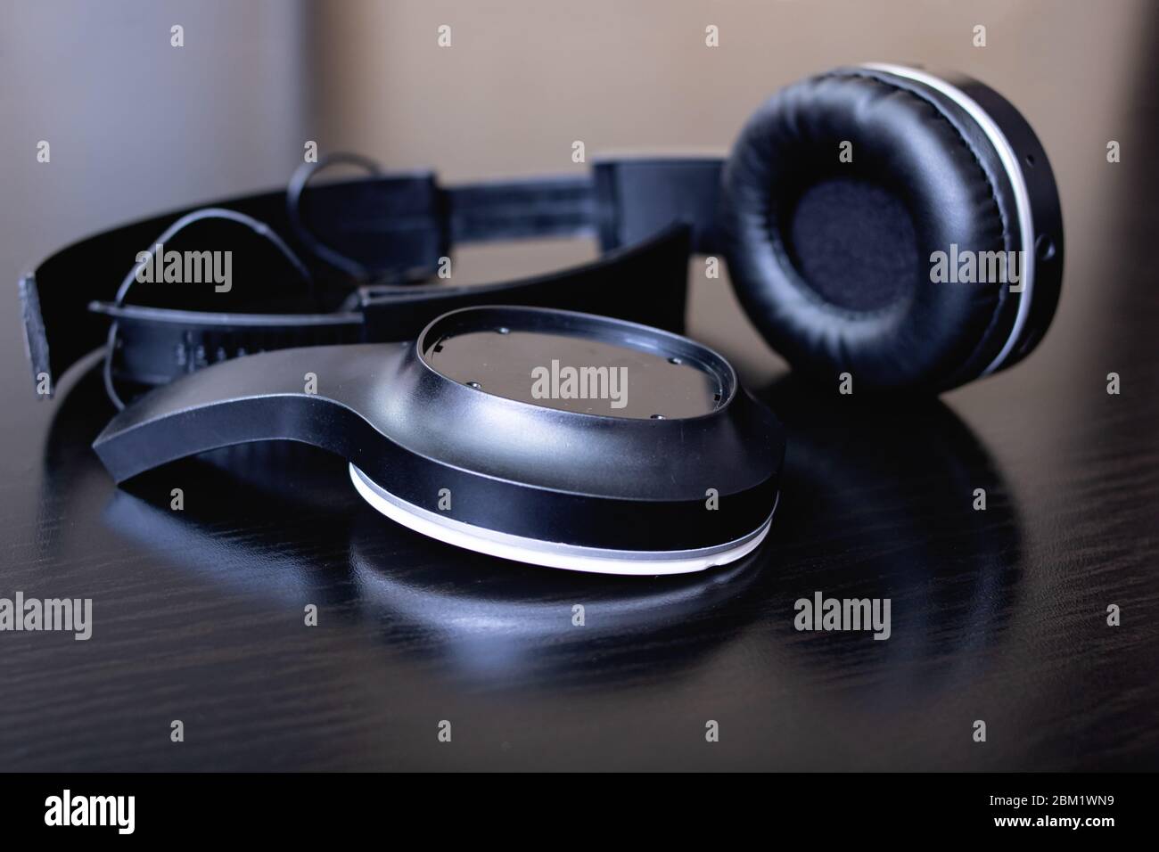 Cuffie nere rotte su un tavolo di legno Foto stock - Alamy