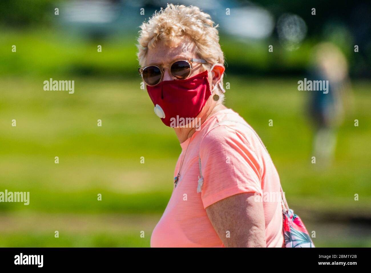 Londra, Regno Unito. 06 maggio 2020. La confusione sulle maschere rimane da chiarire, come una signora più anziana, apparently, indossa una maschera sul suo cammino all'aperto. Le persone più anziane in forma possono decidere se rimanere bloccate: Tutte le età hanno la possibilità di fare esercizio su Wimbeldon Common mentre il sole è fuori. Il blocco continua per l'epidemia di Coronavirus (Covid 19) a Londra. Credit: Guy Bell/Alamy Live News Foto Stock