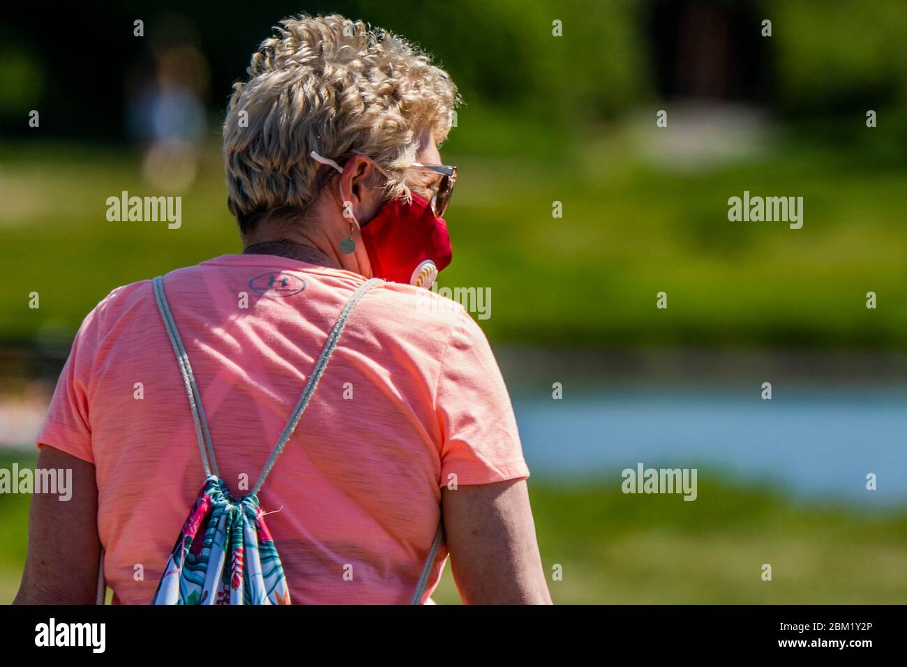 Londra, Regno Unito. 06 maggio 2020. La confusione sulle maschere rimane da chiarire, come una signora più anziana, apparently, indossa una maschera sul suo cammino all'aperto. Le persone più anziane in forma possono decidere se rimanere bloccate: Tutte le età hanno la possibilità di fare esercizio su Wimbeldon Common mentre il sole è fuori. Il blocco continua per l'epidemia di Coronavirus (Covid 19) a Londra. Credit: Guy Bell/Alamy Live News Foto Stock
