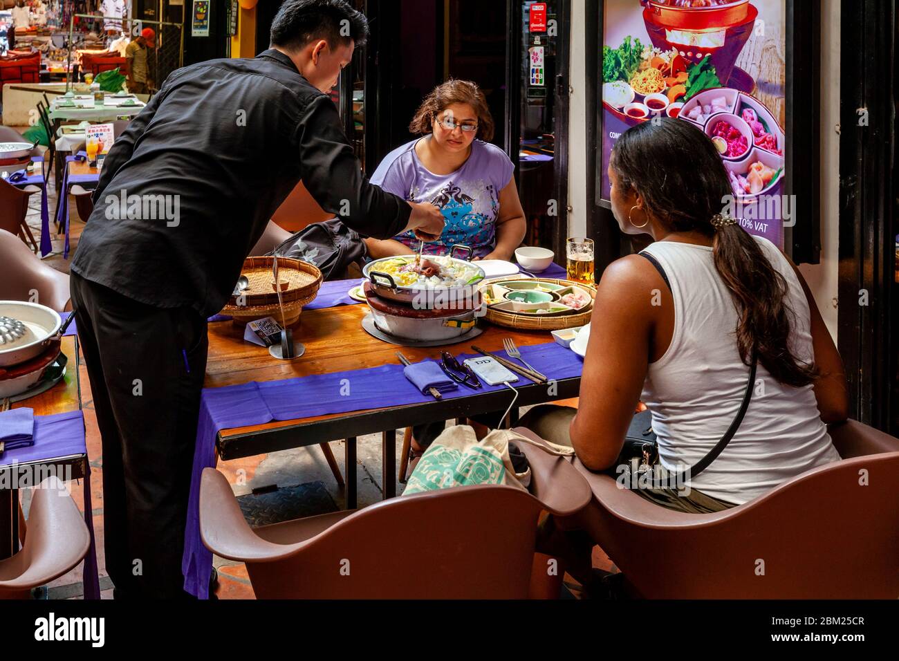 Due turisti femminili che mangiano il pranzo ad UN ristorante nel quartiere vecchio di Siem Reap, provincia di Siem Reap, Cambogia. Foto Stock