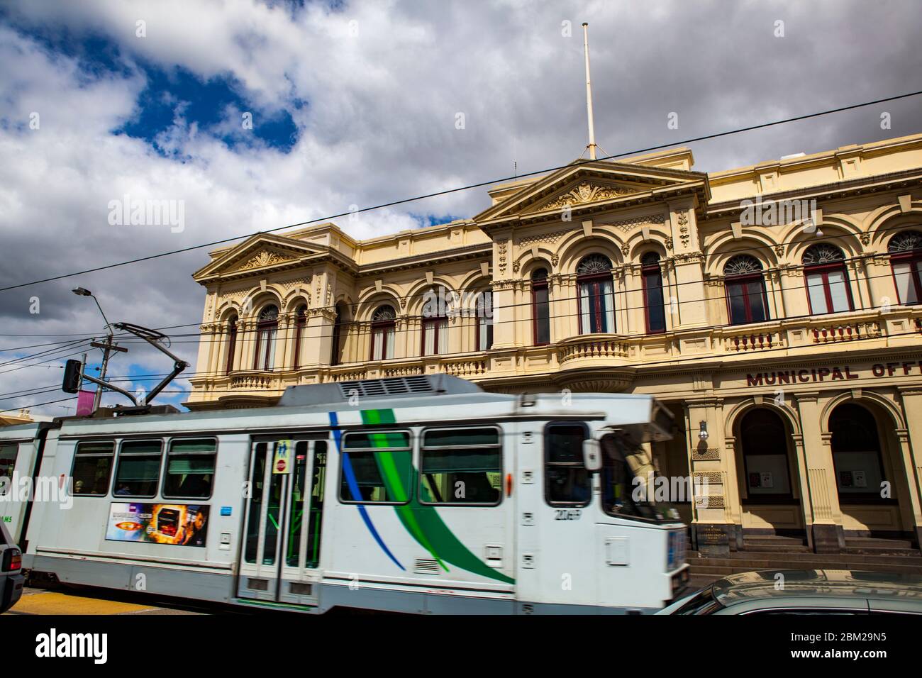 Tram che passa per gli uffici municipali della città di Northcote, Melbourne, Victoria, Australia. Tardo 19 secolo edificio progettato dall'architetto George R Johnson, Foto Stock