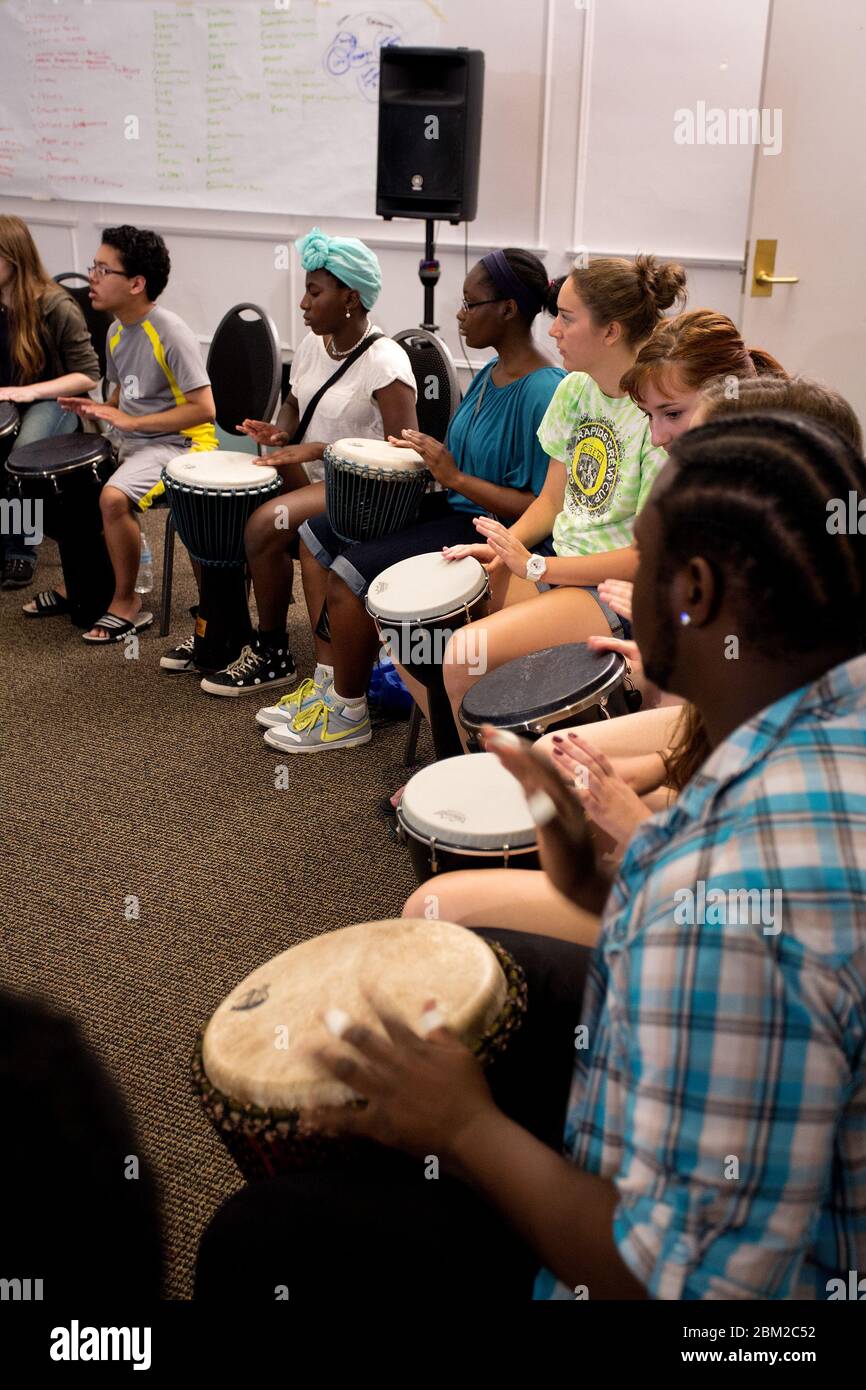 Un gruppo di adolescenti suona la batteria del bongo durante un laboratorio musicale Foto Stock