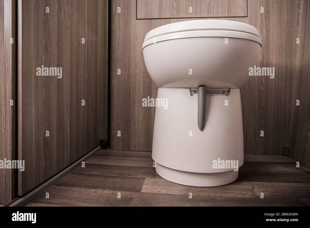 Primo piano del bagno bianco in Tan piccola area di servizi igienici per veicoli ricreativi Cabin. Foto Stock