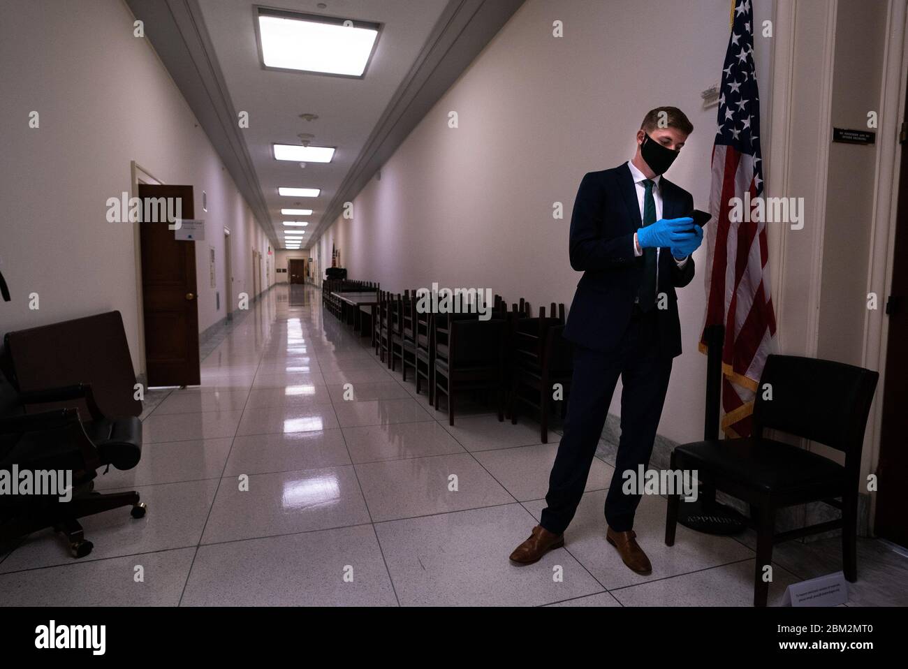 Washington, Stati Uniti. 06 maggio 2020. Un membro dello staff di casa degli stanziamenti indossa i dispositivi di protezione individuale mentre usano il loro telefono fuori della casa degli stanziamenti Sottocomitato audizione sulla risposta COVID-19, su Capitol Hill a Washington, DC Mercoledì, 6 maggio 2020. L'ex amministratore del CDC Tom Frieden e il Dr. Caitlin Rivers, un Senior Scholar presso il Johns Hopkins Center for Health and Security, hanno testimoniato la pandemia di Coronavirus. Foto di Kevin Dietsch/UPI. Credit: UPI/Alamy Live News Foto Stock