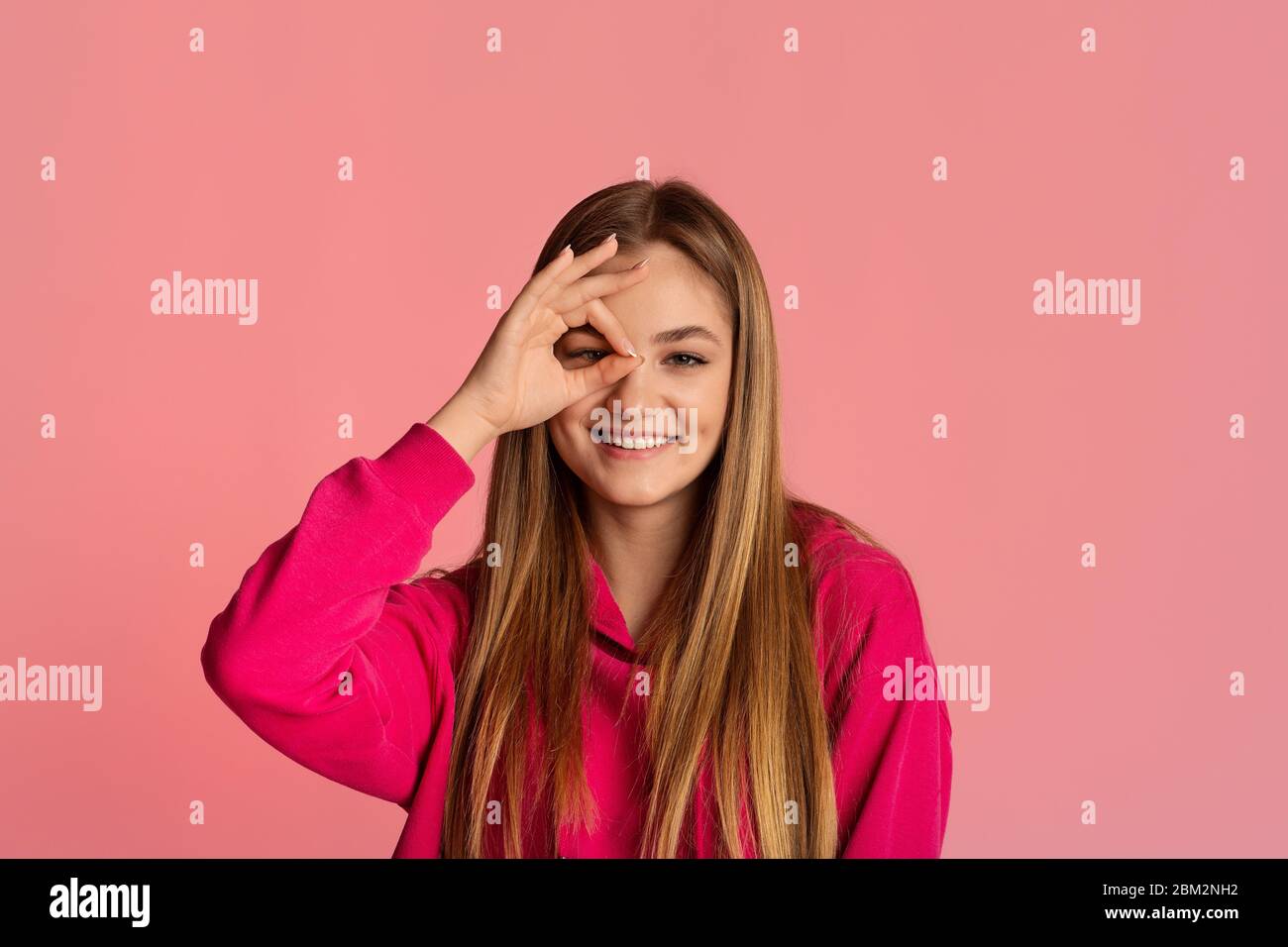 Ragazza adolescente che fa il segno ok con la mano Foto Stock