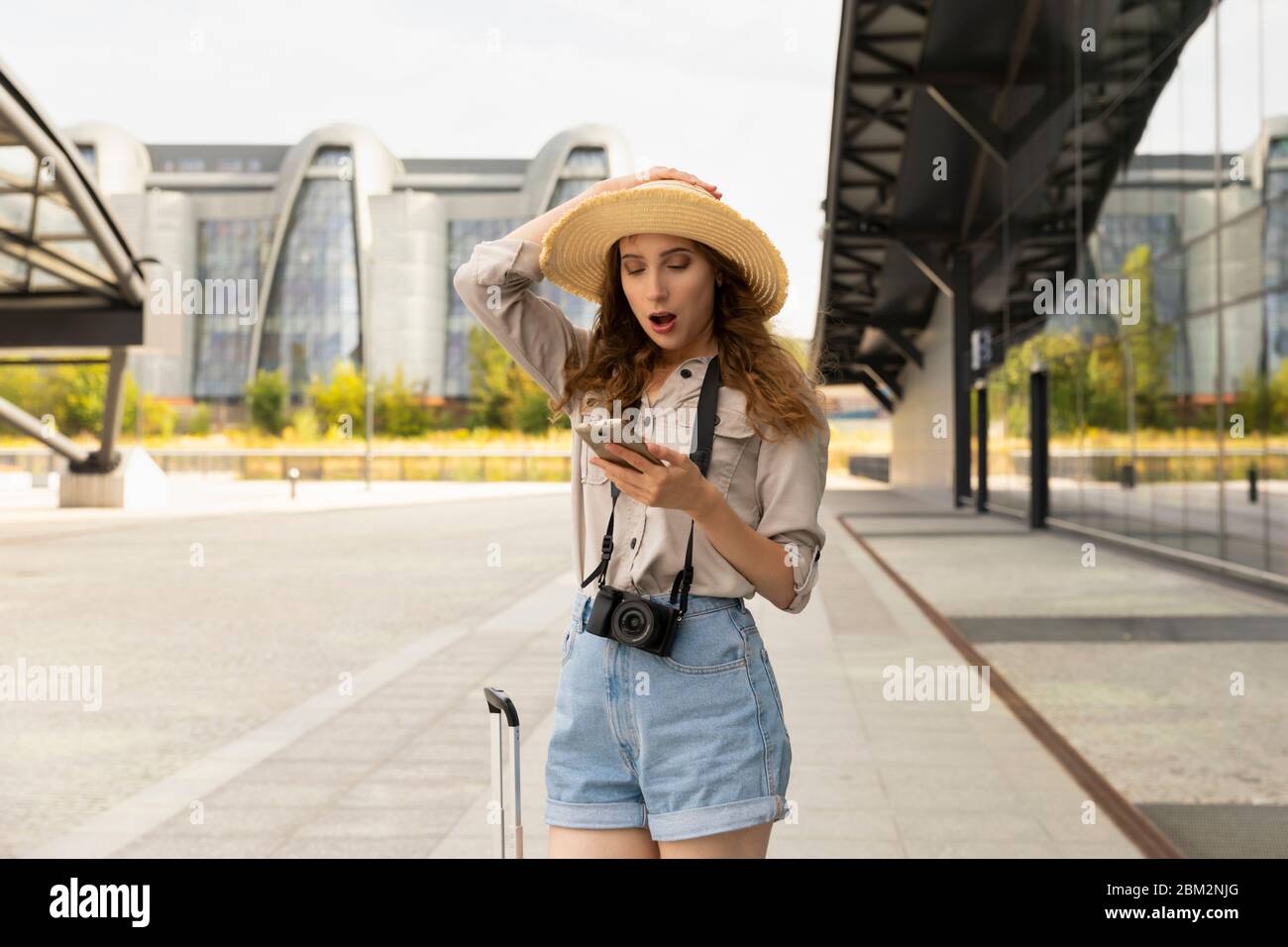 Immagine di giovane eccitato bella donna in posa turistica. Una donna legge un messaggio al telefono, sembra sorpresa. Foto Stock