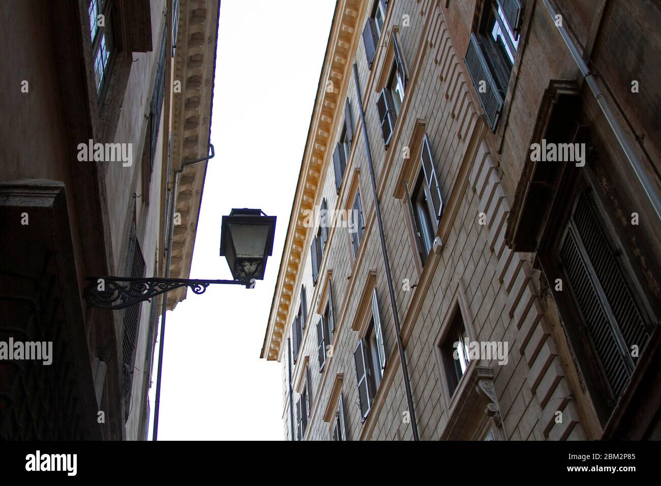 Vista a bassa angolazione di un vecchio lampione circondato da edifici a Trastevere, Roma. Foto Stock
