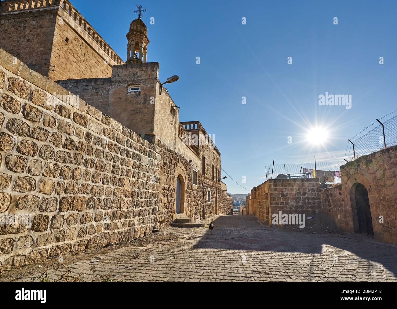 Vecchie strade strette, case tradizionali in pietra e la chiesa di Midyat, Mardin, Turchia Foto Stock