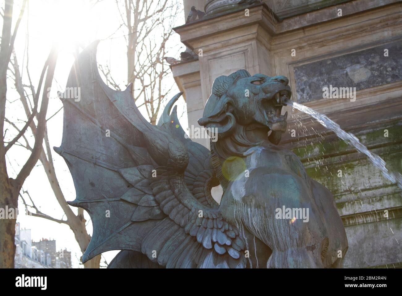 PARIGI, FRANCIA - FEBBRAIO 2020: Statua di bronzo di un griffin o leone alato a Place Sant Michel, sole splendo sullo sfondo Foto Stock
