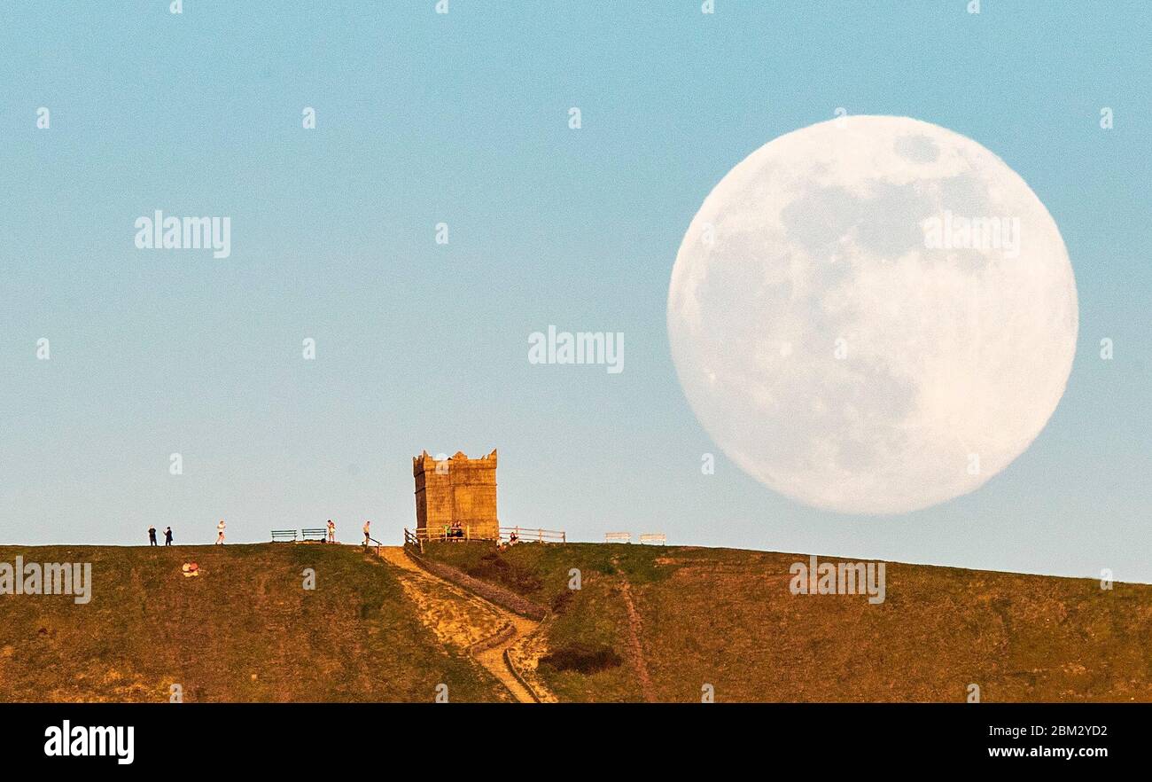 La luna si innalza su Rivington Pike, Bolton, Lancashire, davanti alla finale Supermoon dell'anno, che sarà visibile in Gran Bretagna giovedì sera. La luna piena di maggio è anche conosciuta come la "luna di fiori", che significa i fiori che fioriscono durante il mese. Foto PA. Data foto: Mercoledì 6 maggio 2020. La luna piena di questo mese è anche la superluna, il che significa che sarà circa il 6% più grande di una luna piena tipica e circa il 14% più grande di una microluna, che è quando la luna è al suo punto più lontano dalla Terra. Vedi la storia della PA SCIENCE Supermoon. Il credito per le foto dovrebbe essere: Peter Byrne/PA Wi Foto Stock