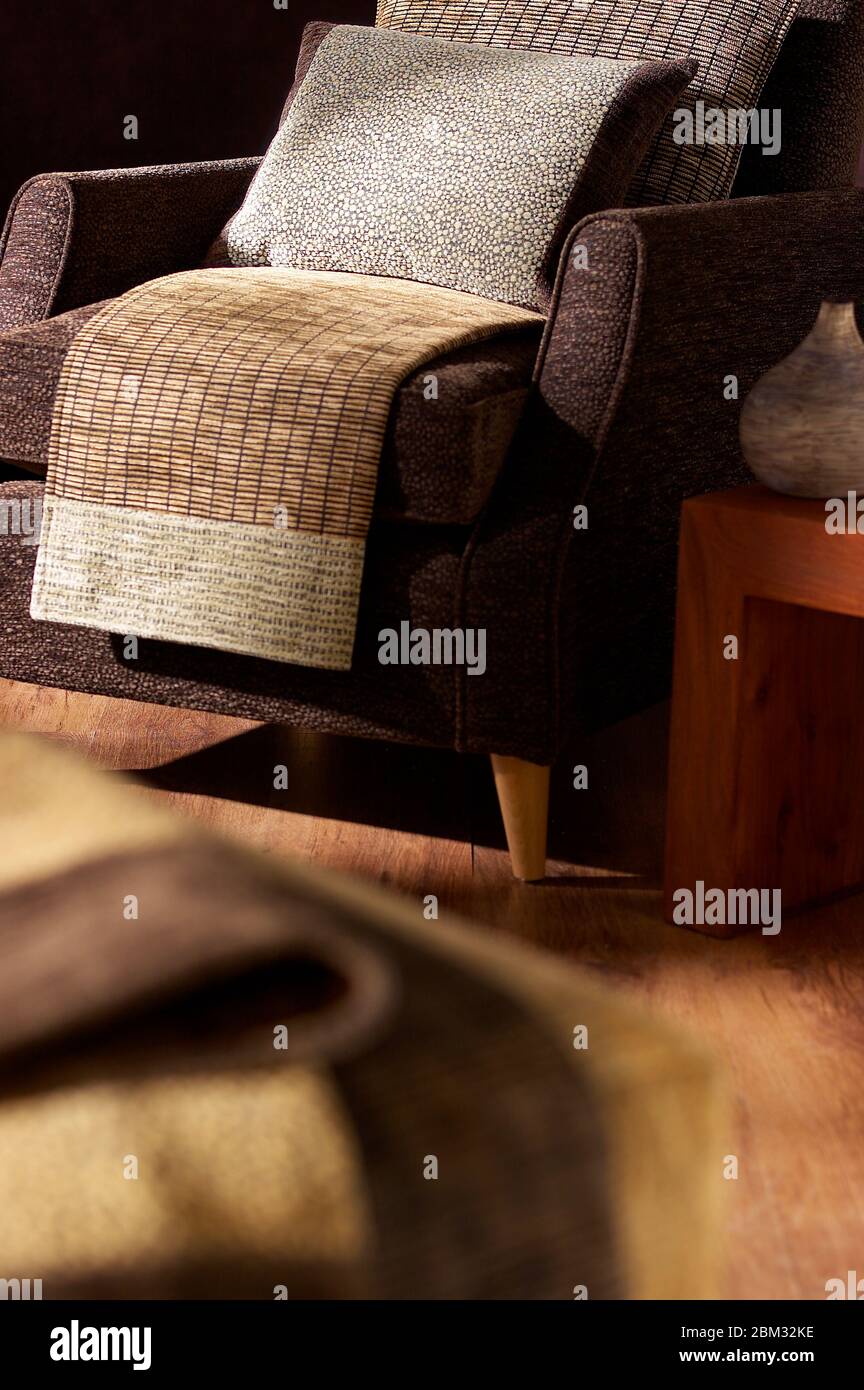 Camera con poltrona di colore marrone e cuscini in soggiorno Foto Stock