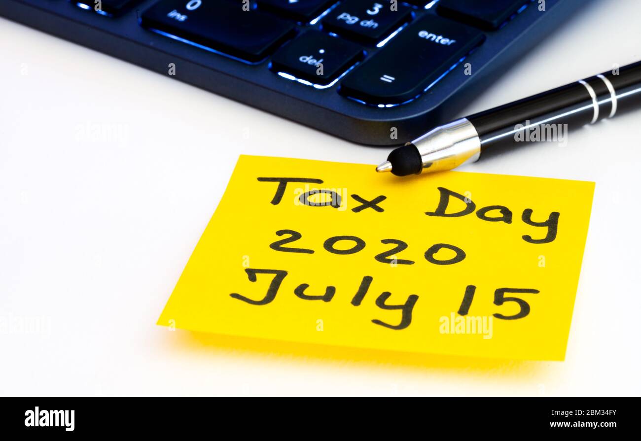Giorno fiscale rinviato dal governo americano al 15 luglio 2020. Informazioni sui promemoria fiscali con nota adesiva gialla, tastiera e penna del computer illuminate Foto Stock
