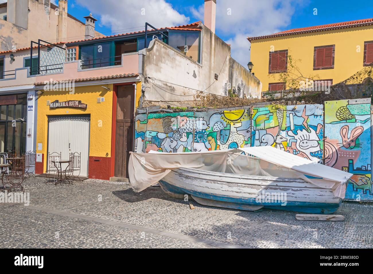 Funchal, Portogallo - 10 novembre 2019: Barca da pesca e muro dipinto sulla strada Rua Portao de Sao Tiago come parte del progetto 'arte delle porte aperte Foto Stock