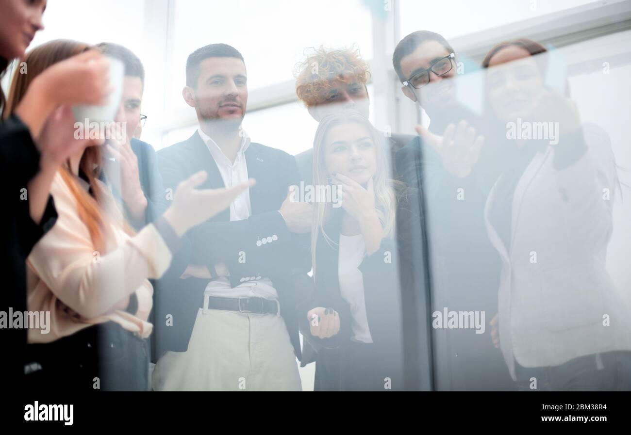 giovane donna di affari che incolla la nota adesiva sulla parete di vetro. Foto Stock