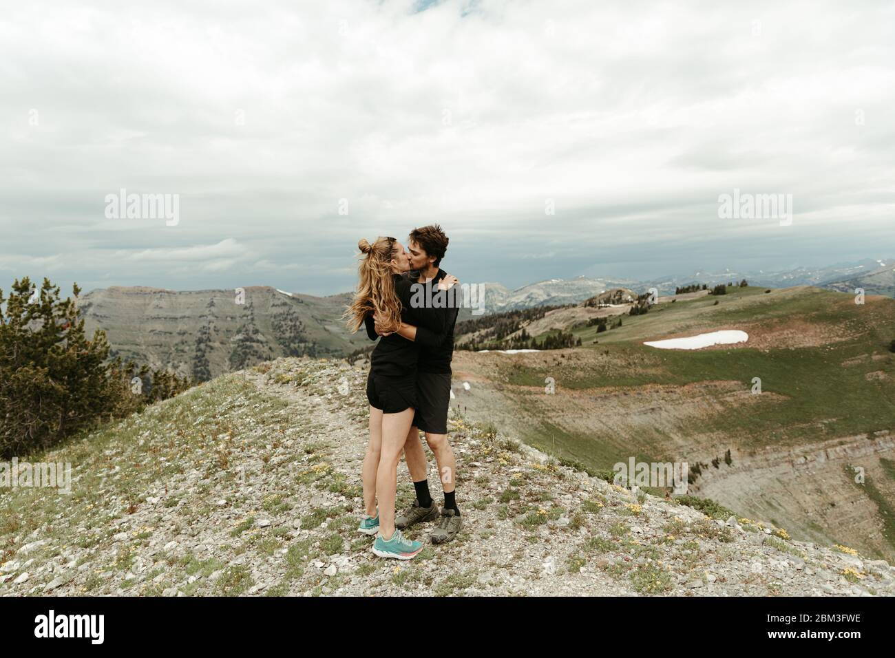 nuovo fidanzato bacio di coppia bianca su una cima di montagna dentro wyoming Foto Stock