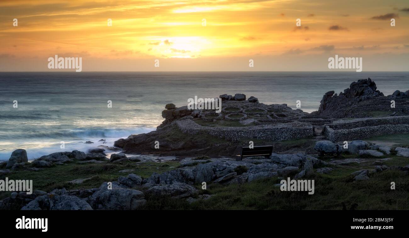 Panchina sulla costa con splendida vista sulle antiche rovine Foto Stock