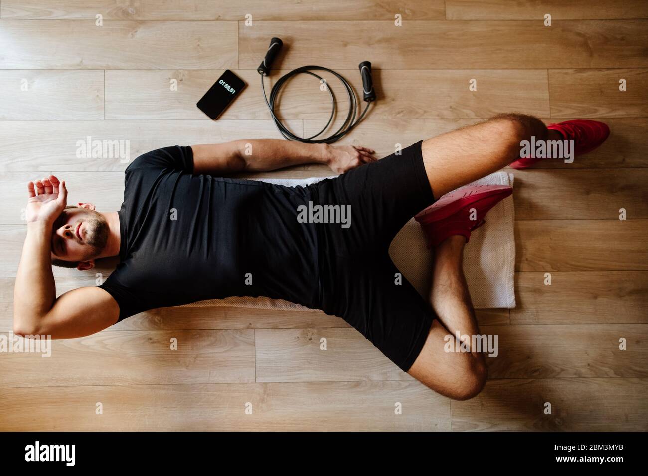 atleta con sindrome sovraallenato si appoggia sul pavimento. allenati. atleta stanco e sfinito. Foto Stock