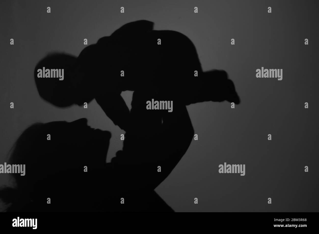 Silhouette di Madre e Bambino felice. Mamma sorridente al bambino, felice concetto di Festa della mamma Foto Stock