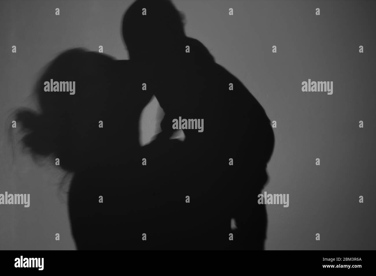 Silhouette di Madre e Bambino felice. Mamma bacia il bambino, felice concetto di Festa della mamma Foto Stock