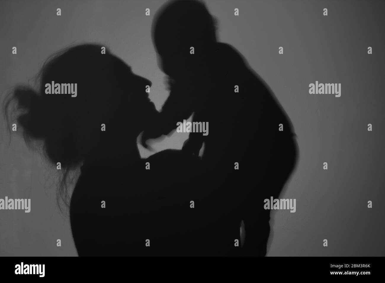 Silhouette di Madre e Bambino felice. Mamma sorridente al bambino, felice concetto di Festa della mamma Foto Stock