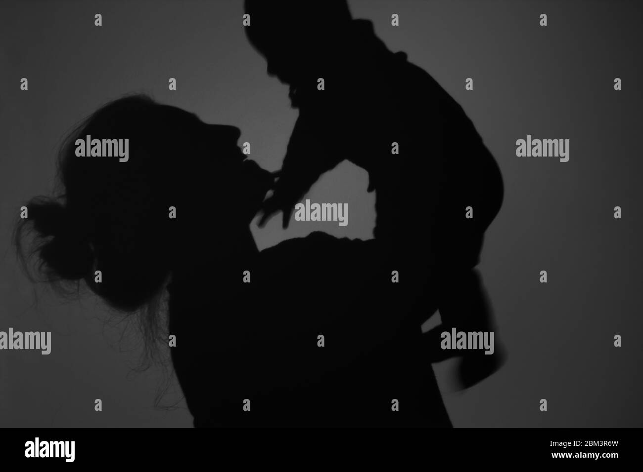 Silhouette di Madre e Bambino felice. Mamma sorridente al bambino, felice concetto di Festa della mamma Foto Stock