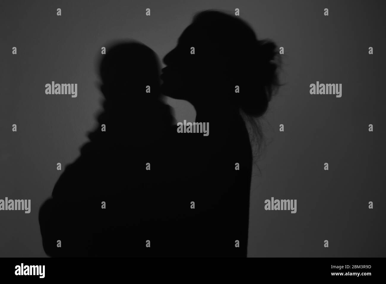 Silhouette di Madre e Bambino felice. Mamma bacia il bambino, felice concetto di Festa della mamma Foto Stock