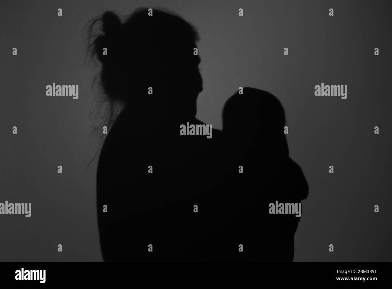 Silhouette di Madre e Bambino felice. Mamma sorridente al bambino, felice concetto di Festa della mamma Foto Stock