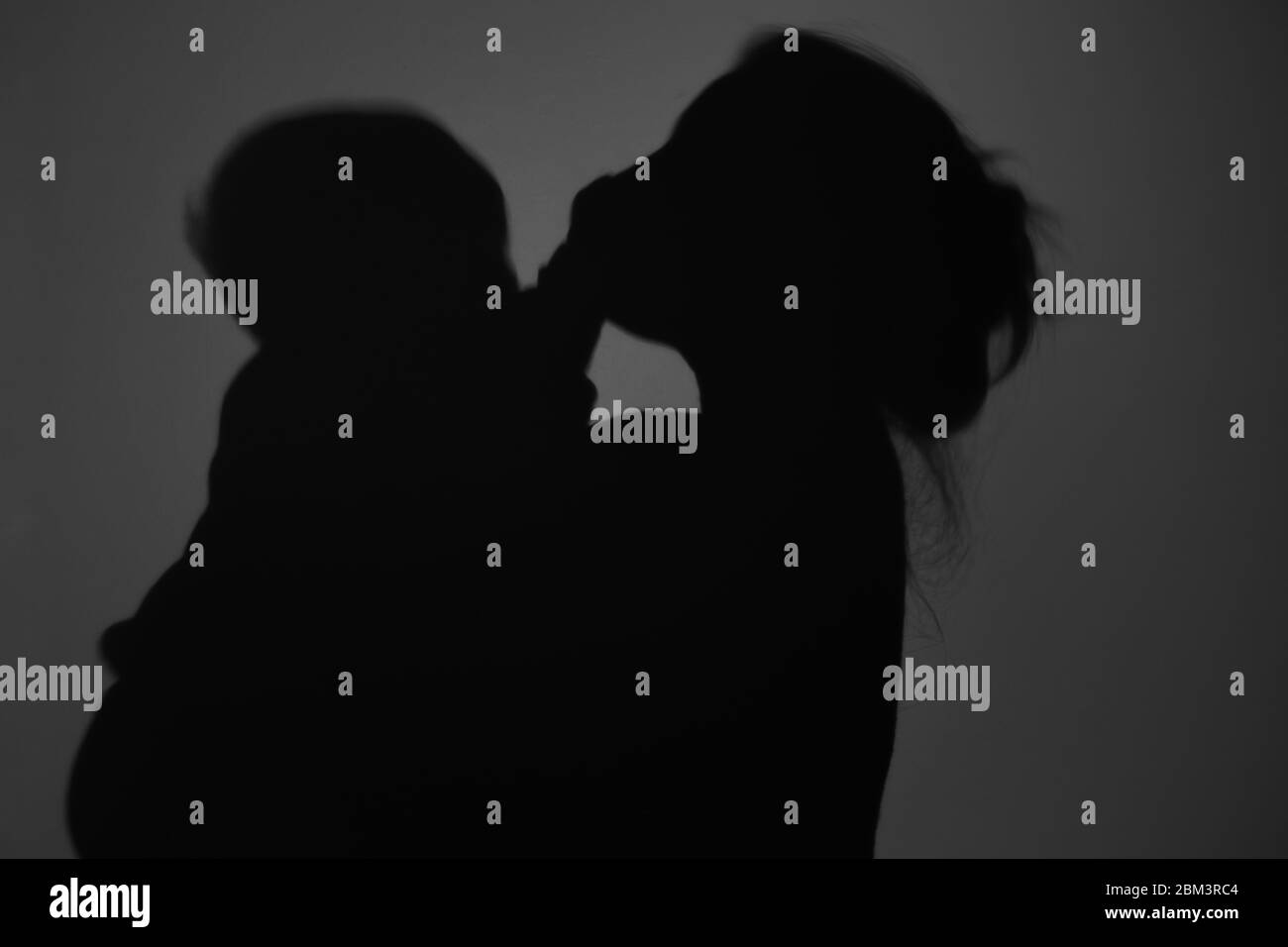 Silhouette di Madre e Bambino felice. Mamma bacia il bambino, felice concetto di Festa della mamma Foto Stock