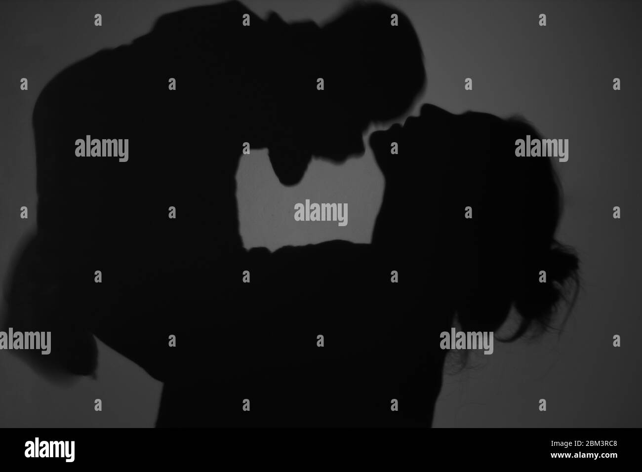 Silhouette di Madre e Bambino felice. Mamma bacia il bambino, felice concetto di Festa della mamma Foto Stock