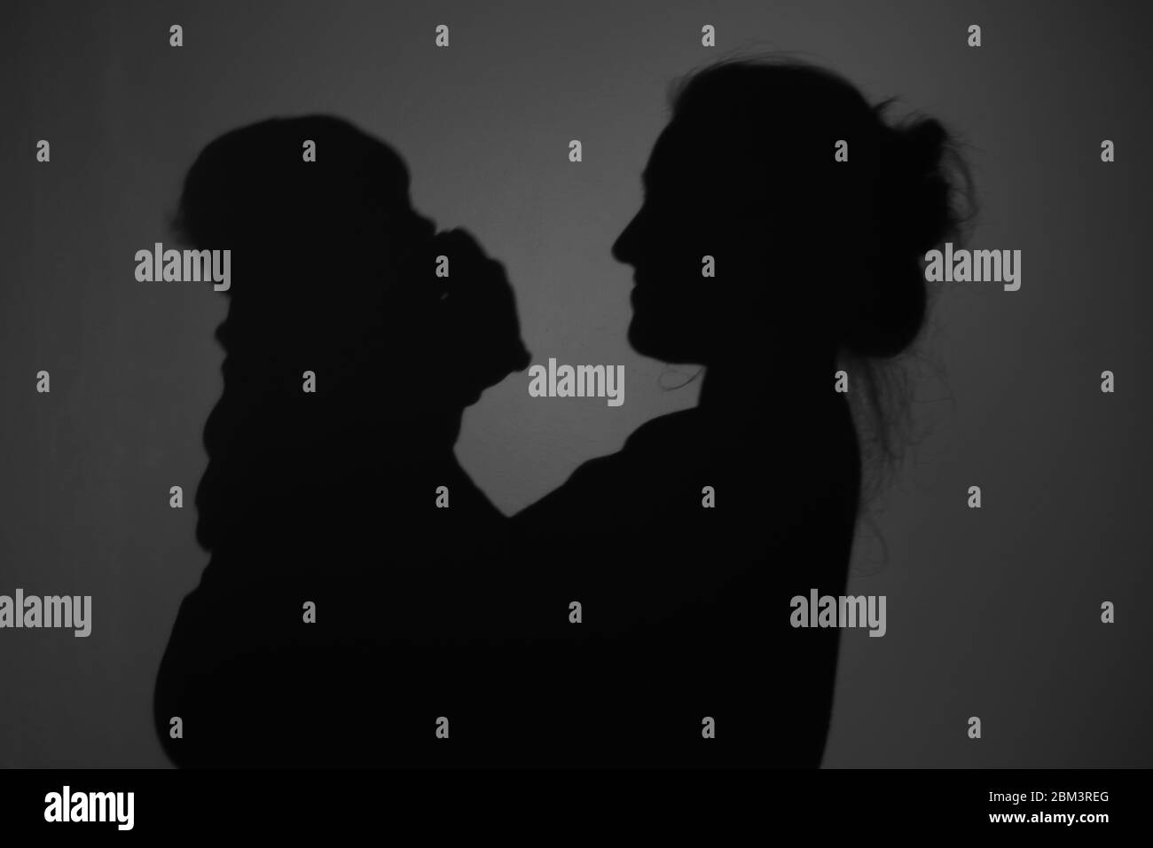 Silhouette di Madre e Bambino felice. Mamma sorridente al bambino, felice concetto di Festa della mamma Foto Stock