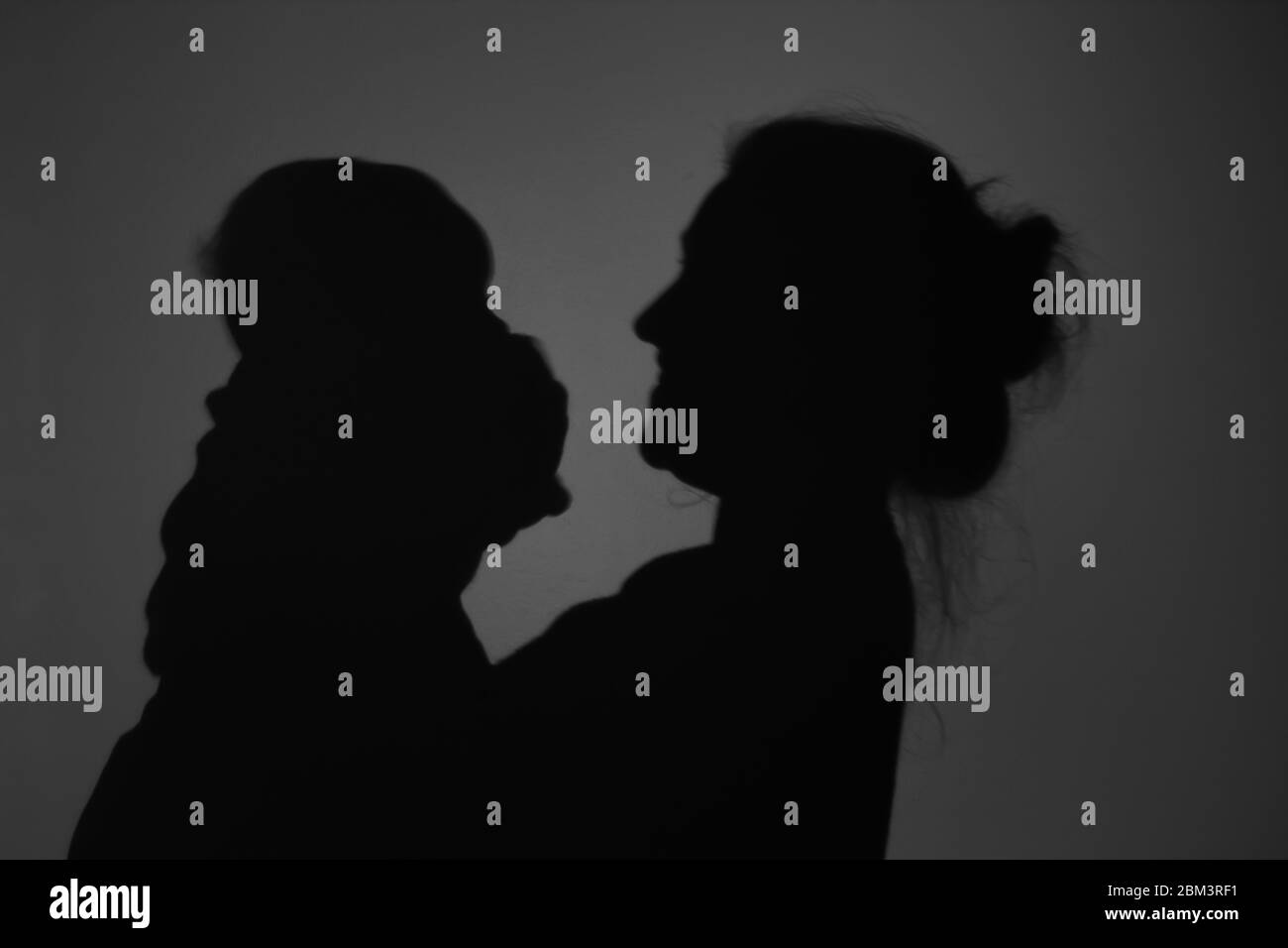 Silhouette di Madre e Bambino felice. Mamma sorridente al bambino, felice concetto di Festa della mamma Foto Stock