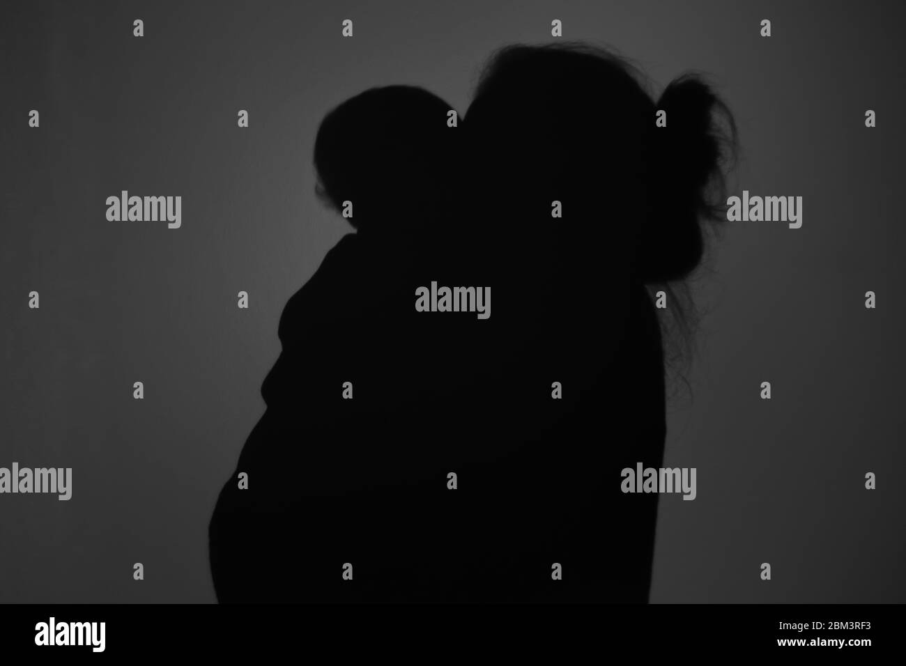 Silhouette di Madre e Bambino felice. Mamma sorridente al bambino, felice concetto di Festa della mamma Foto Stock