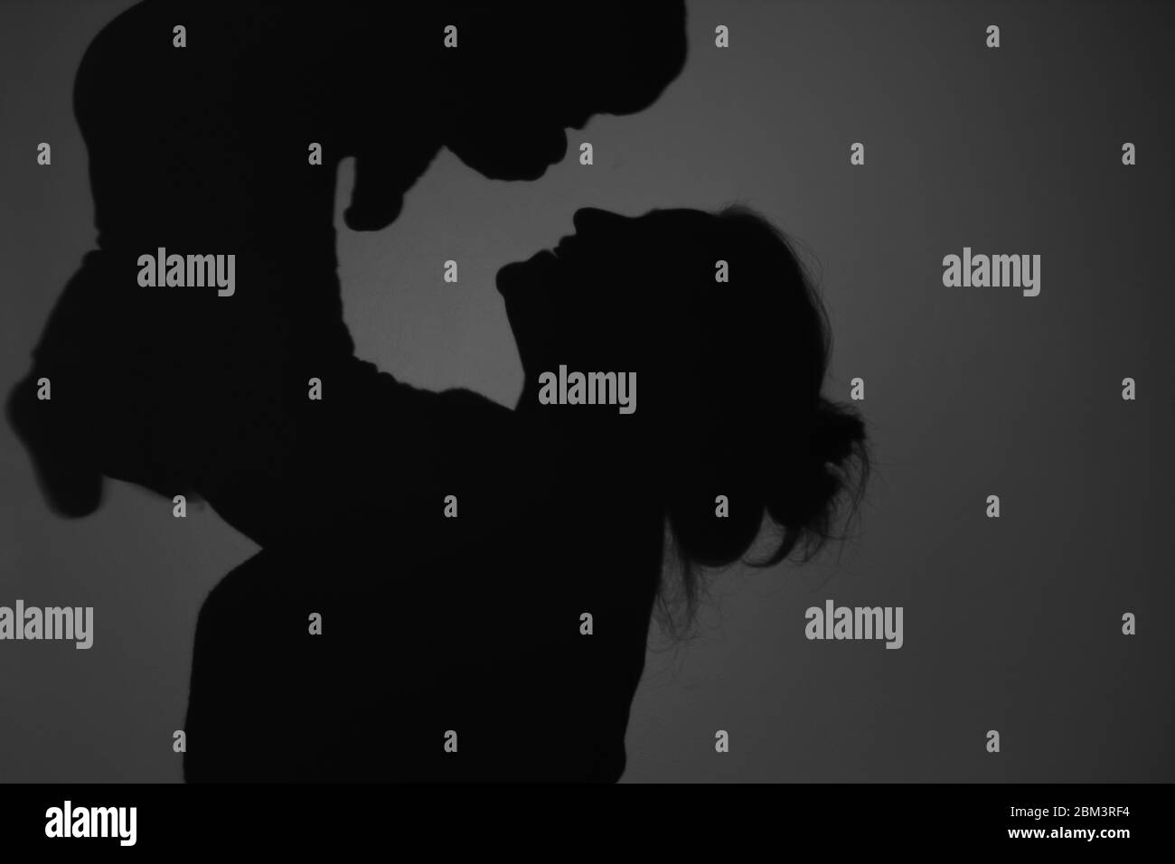 Silhouette di Madre e Bambino felice. Mamma sorridente al bambino, felice concetto di Festa della mamma Foto Stock