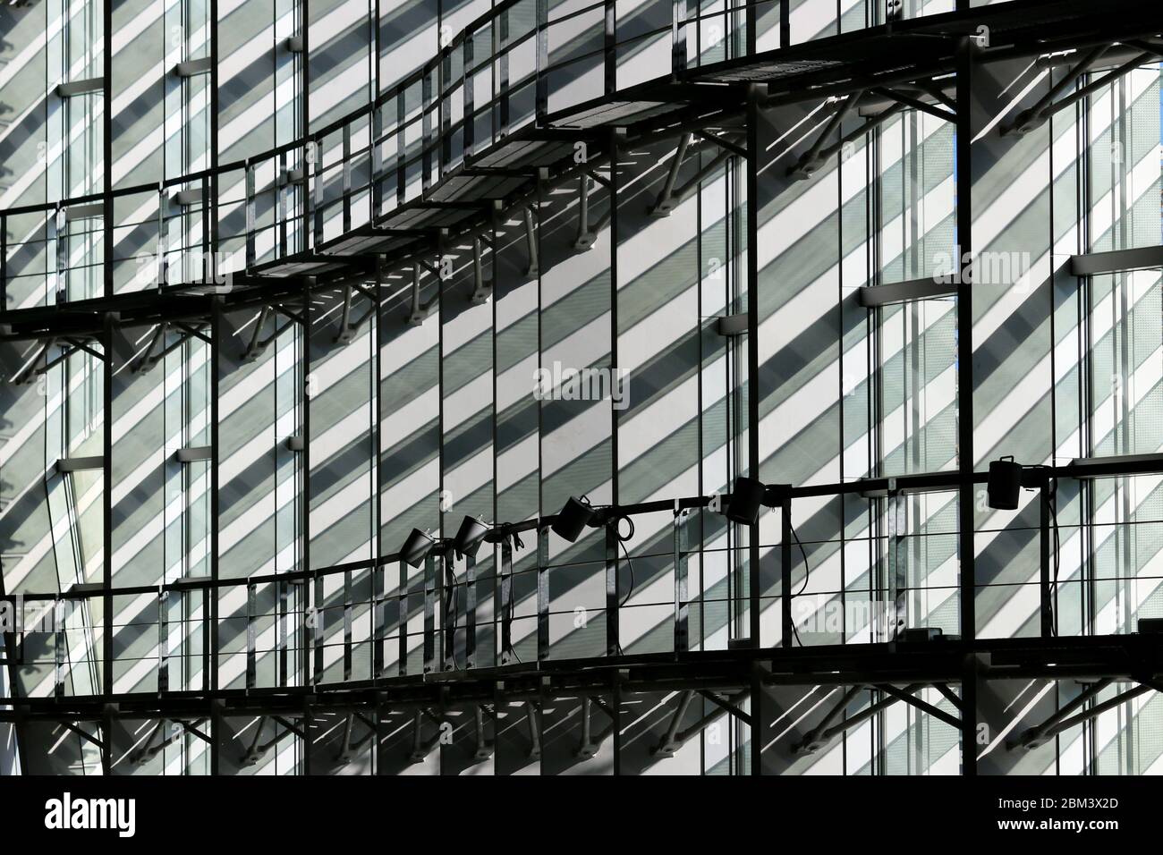 La parete di un edificio in vetro costruito con linee dritte e curve Foto Stock