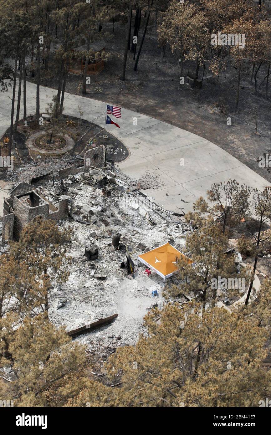 Bastrop Texas USA, settembre 16 2011: I residenti tornano a casa distrutta dopo massicci incendi boschivi spazzati attraverso quartieri boschivi, bruciando più di 1400 case nella zona all'inizio di settembre. Hanno allestito una tenda dove stanno smistando attraverso le macerie. ©Bob Daemmrich Foto Stock