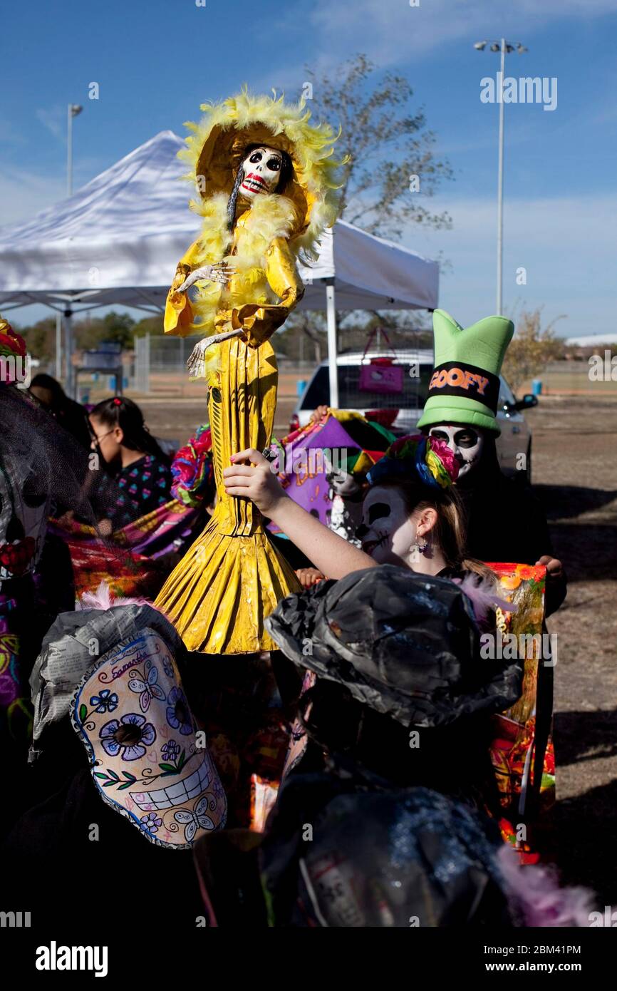 Kyle Texas USA, novembre 5 2011: Il bambino con il volto dipinto tiene una "catrina", una figura scheletrica simile a una bambola, mentre si esibisce alla celebrazione annuale di Kyle, TX, "Day of the Dead" o dia de Los Muertos, appena a sud di Austin. Day of the Dead è una festa nazionale messicana celebrata in tutto il Messico e si concentra su riunioni di familiari e amici per pregare per un ricordo dei defunti cari. ©Bob Daemmrich Foto Stock