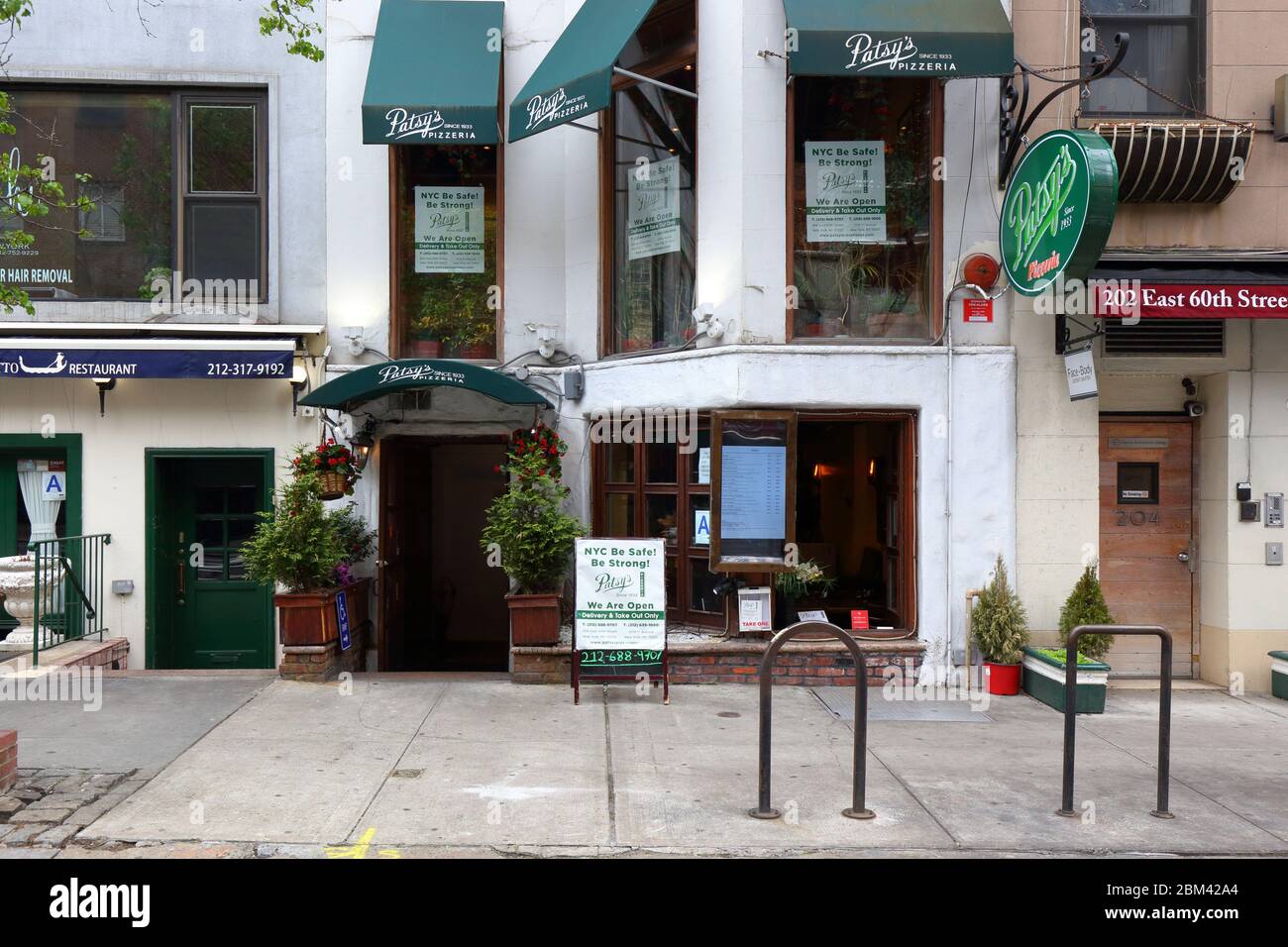La Pizzeria di Patsy's nell'Upper East Side di New York con segnaletica che annuncia è aperta per il servizio di take out e consegna durante il coronavirus COVID-19 Foto Stock