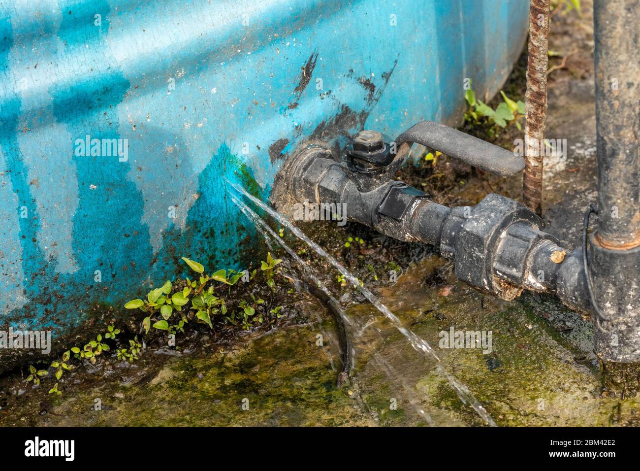 Perdite di acqua da incrinature nel serbatoio dell'acqua installato sul tetto della casa. Foto Stock