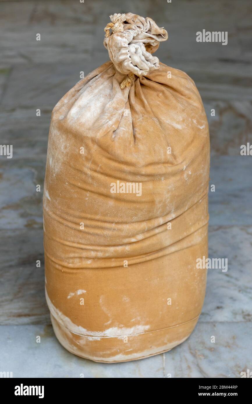 Farina in sacco a burlap grande, sacco con farina di grano, adagiato sul pavimento. Foto Stock