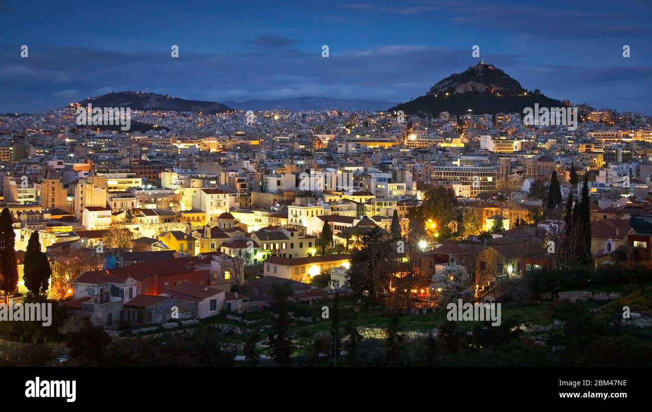 Vista della notte Atene e Likabetus collina dalla collina Areios Pagos dove le prove si svolgevano in tempi antichi. Foto Stock
