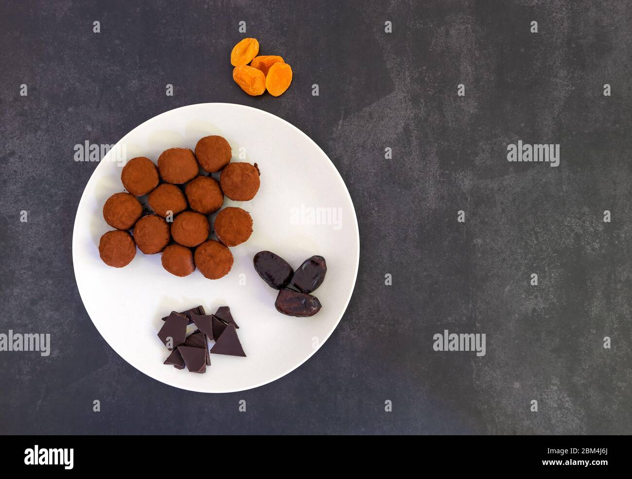 Palle di energia sane con cacao su sfondo scuro Foto Stock