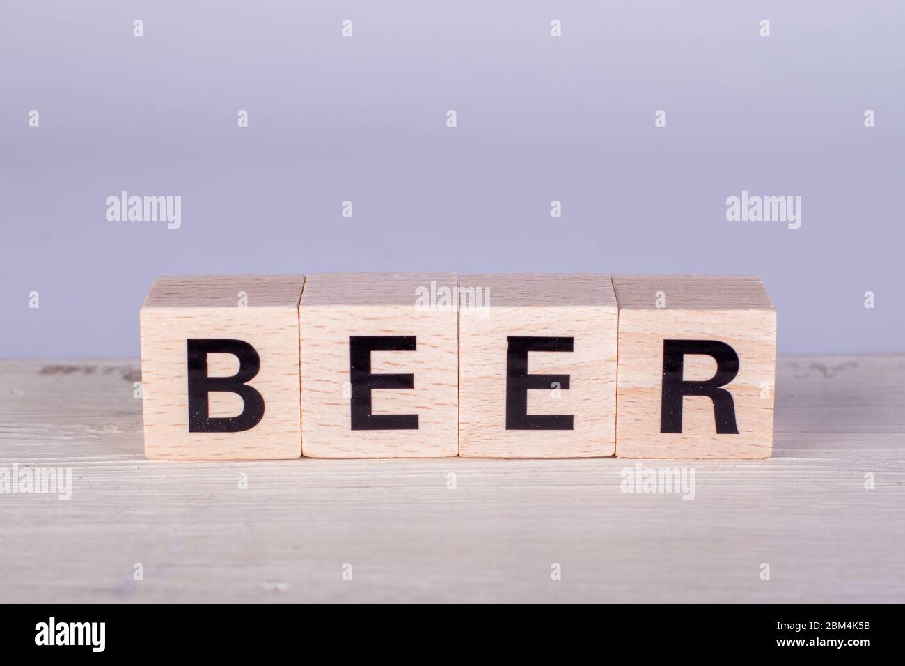 cubi di legno che costruiscono la parola birra, sfondo bianco e asse Foto Stock