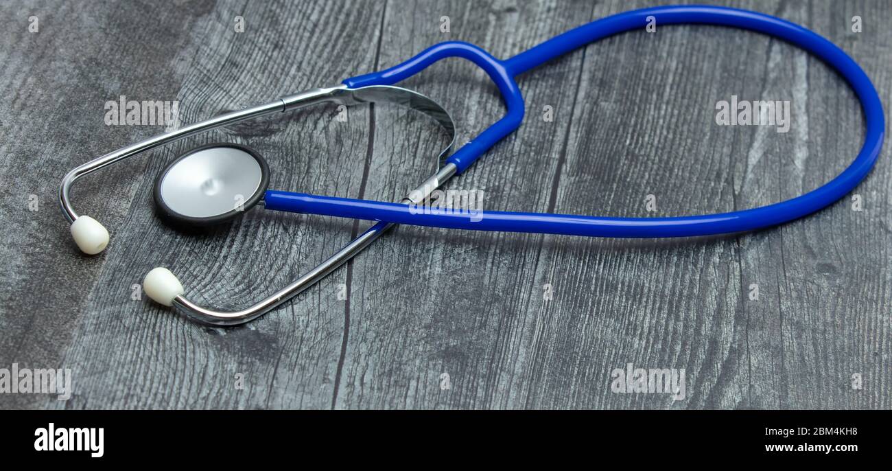 Uno stetoscopio medico blu isolato su un tavolo di legno. Foto Stock