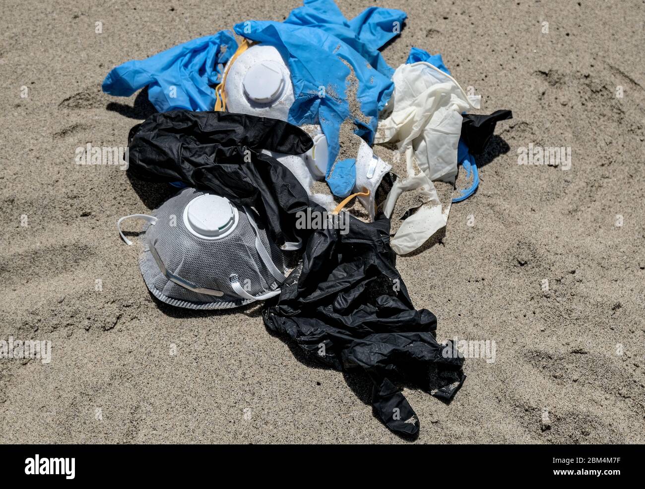 Maschera virus e guanti di plastica spazzatura sulla costa del mare, inquinamento da coronavirus Foto Stock