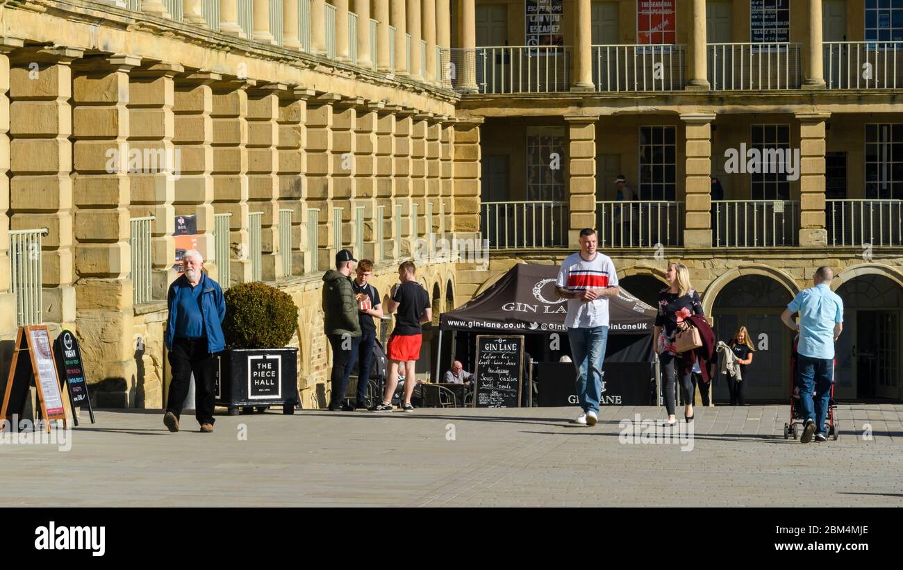 Attrazione storica del cortile Piece Hall (visitatori che si rilassano nella soleggiata piazza, camminano per caffè e colonnati) - Halifax, West Yorkshire, Inghilterra, Regno Unito. Foto Stock