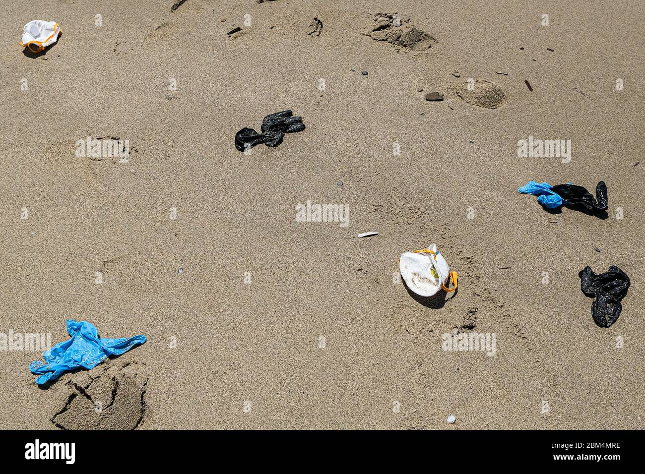 Maschera antivirus e guanti di plastica spazzatura sulla linea costiera del mare, inquinamento da cocvidi coronavirus Foto Stock